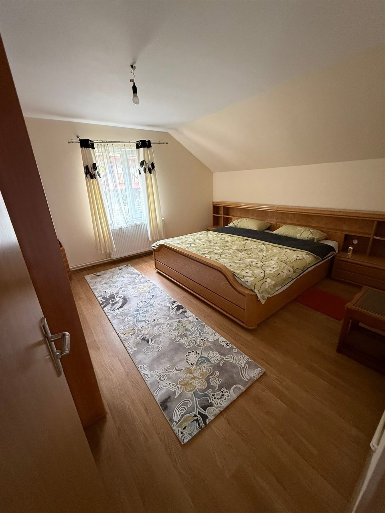 Dormitor la mansardă cu pat dublu din lemn